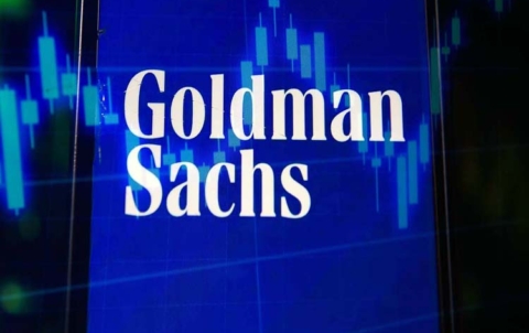 In this photo illustration a multiple exposure image shows a Goldman Sachs logo displayed on a smartphone with stock market percentages on the background.